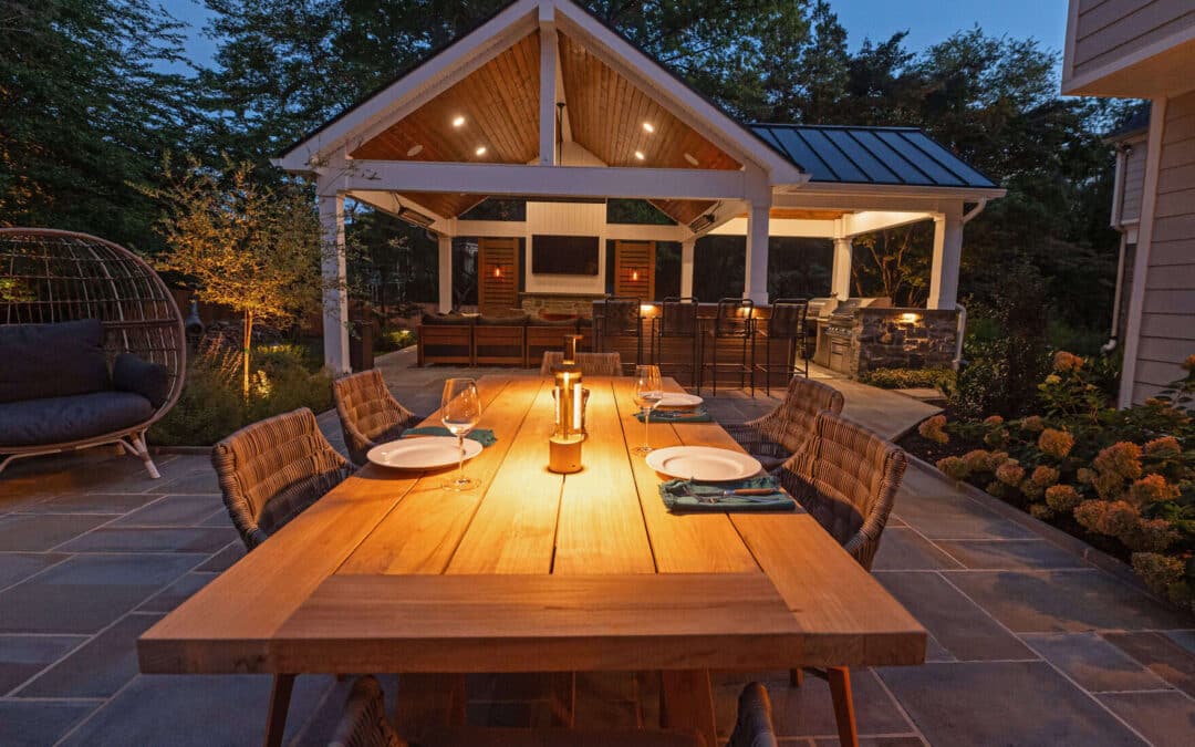 Night view of wet laid flagstone patio with outdoor kitchen and roof structure in Chester County