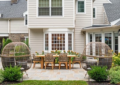Wet laid flagstone patio with dining table and wicker pod chairs in West Chester