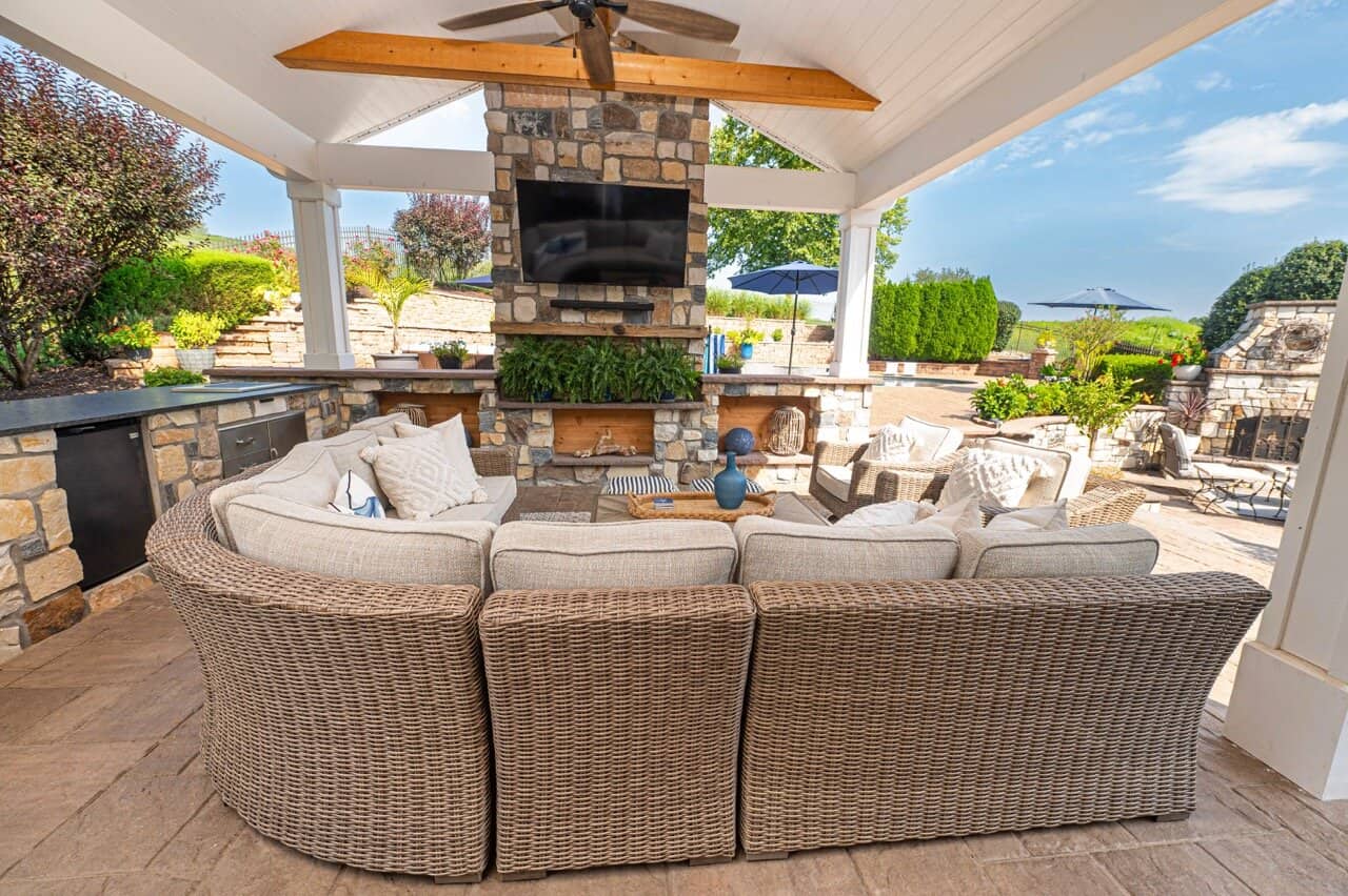 Covered outdoor living room with stone fireplace in Wayne PA.