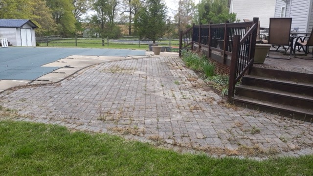 Before paver patio restoration and enhancement in West Chester PA showing moss removal and joint sand replacement.