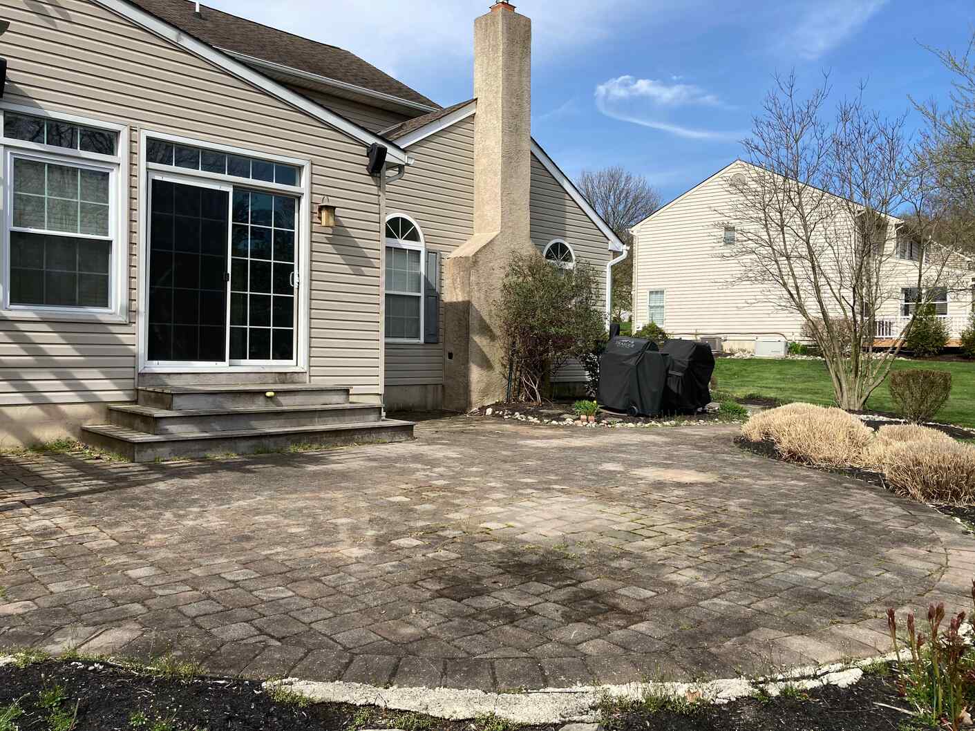 Paver-Patio-Cleaning-Sealing-Restoration-West-Chester-PA Before and after paver patio cleaning and sealing restoration in West Chester PA showing moss removal and joint sand replacement.