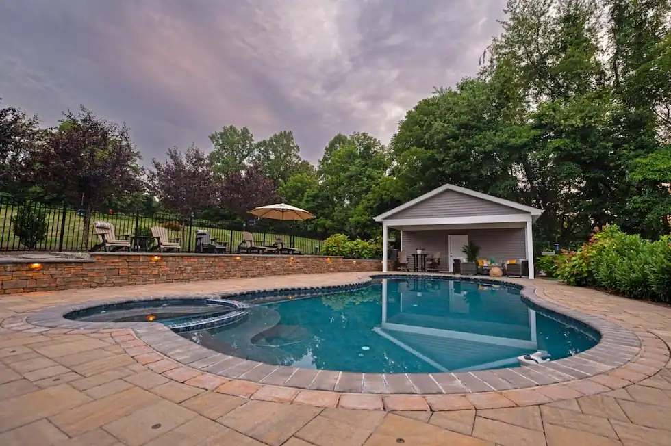 Luxury-Inground-Pool-Patio-Chadds-Ford Resort-style swimming pool with Belgard paver decking and landscape lighting in Chadds Ford