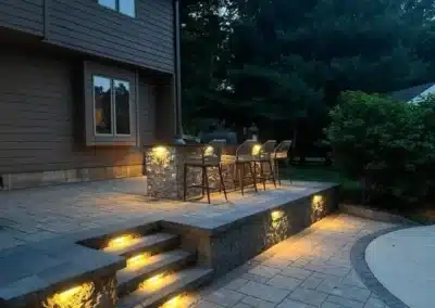 Multi-level raised patio installation with outdoor kitchen and LED lighting in West Chester PA